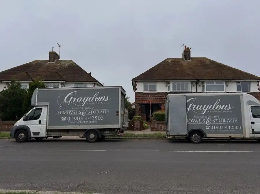 House with 2 removal vans outside.
