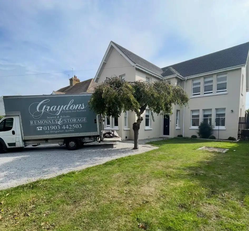 Large house with tree outside and removal van.